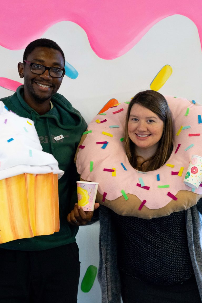 Young couple posing with cupcake and donut props