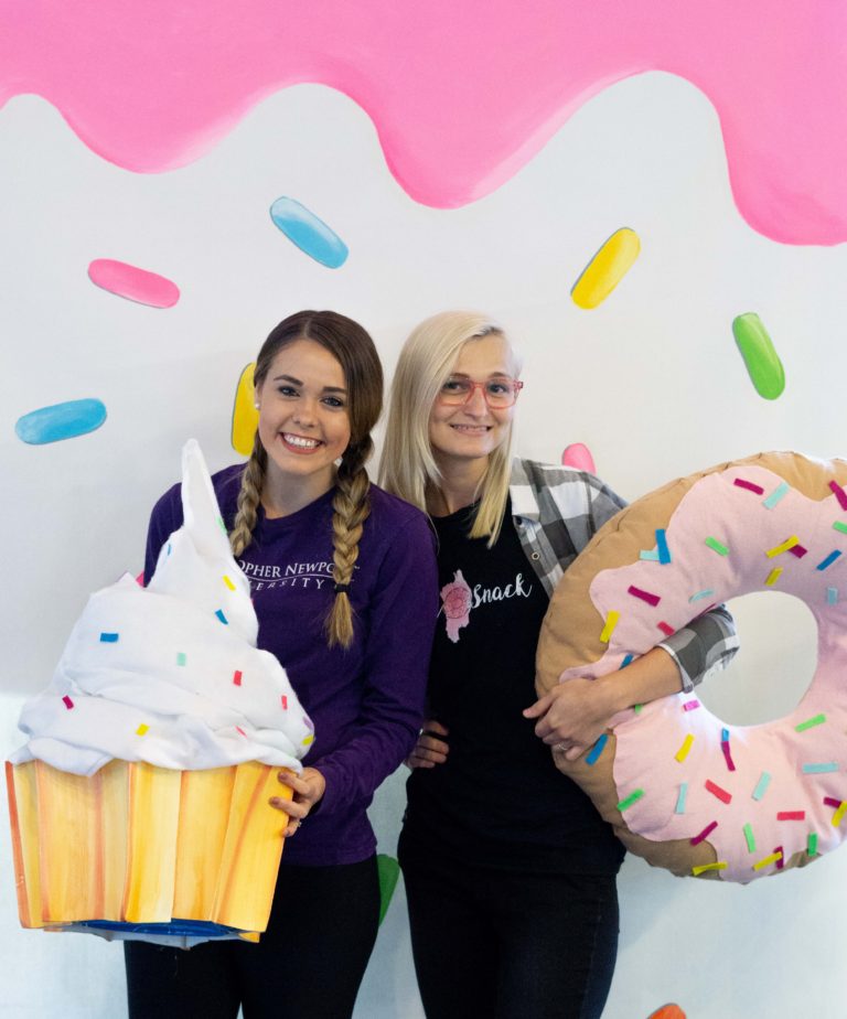 Morgan and Volta posing in front of the sprinkled donut wall