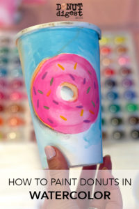 Pink watercolor donut painted on a coffee cup